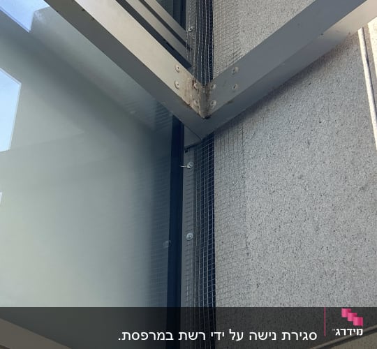 רשת מתכת מותקנת על מבנה למניעת כניסת יונים